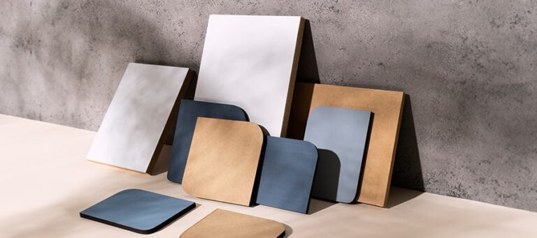 Verschiedene Größen brauner und blauer Ordner, ordentlich angeordnet vor einem strukturierten Treppengeländer.