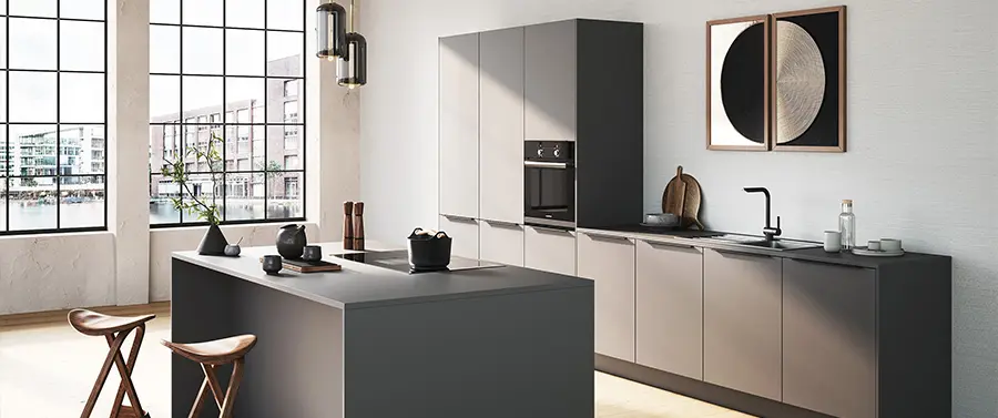 Ein modernes Küchenstudio mit schlanken grauen Schränken und Arbeitsplatten, präsentiert eine zentrale Insel, einen Barhocker und einen Blick auf einen Tisch