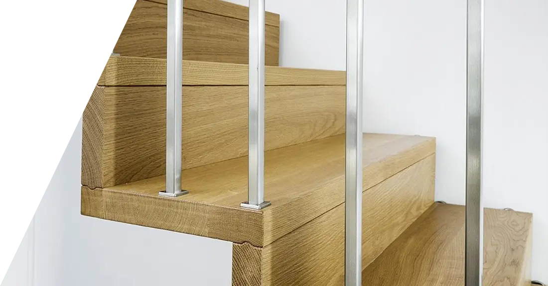 Eine Nahaufnahme moderner Treppenmaterialien mit Metallbalustern und Glasverkleidung.