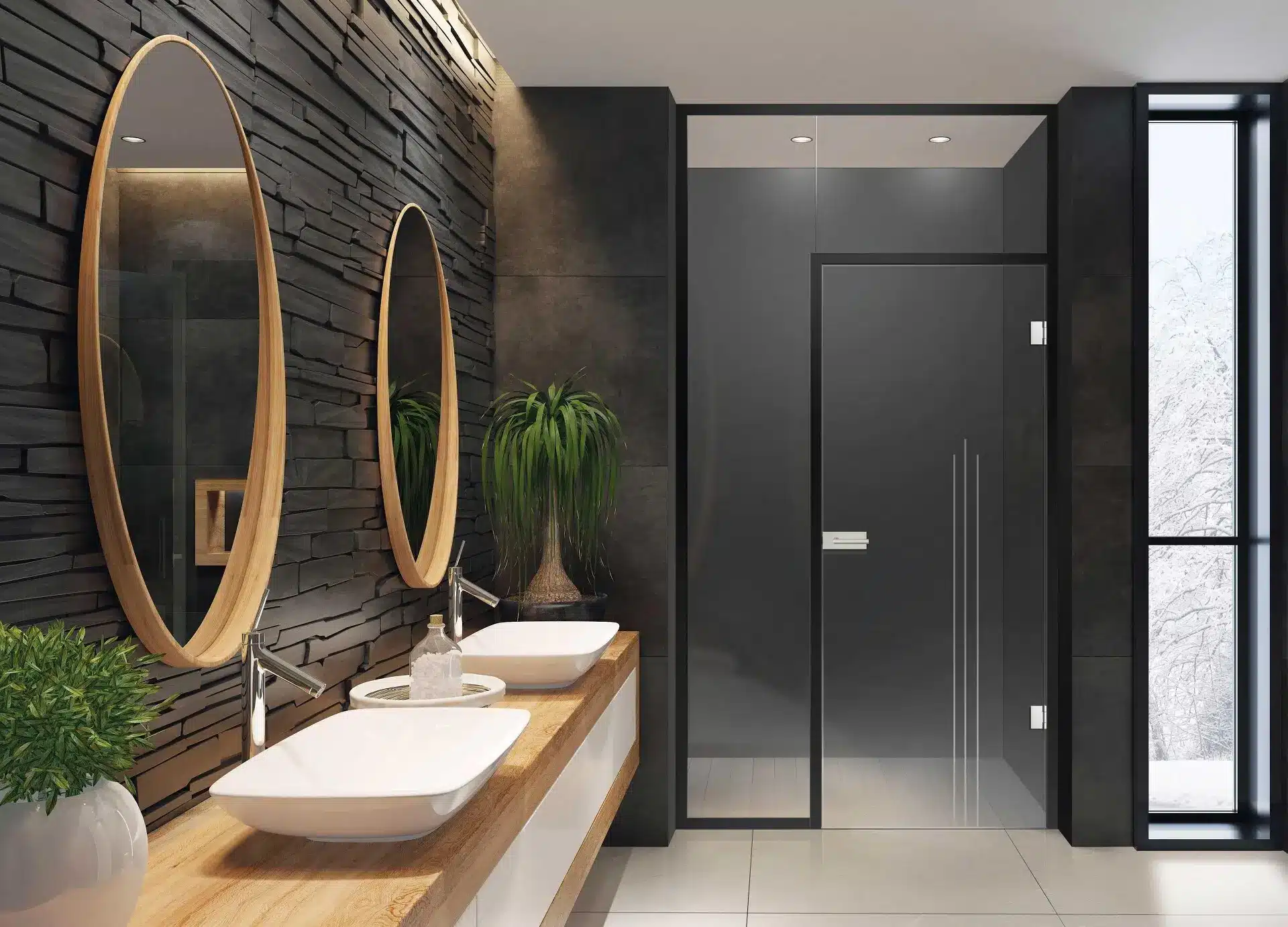 Ein modernes Badezimmer mit zwei ovalen Spiegeln über einem Doppelwaschtisch mit Aufsatzwaschbecken, mattschwarzen Wandfliesen, einer Glasduschkabine (Glasanlagen) und natürlichem Licht durch ein großes Fenster.