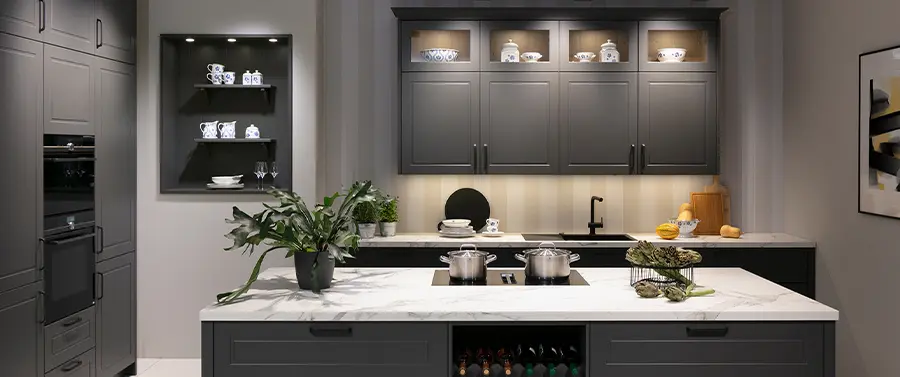 Eine moderne Küche mit grauen Schränken, Küchengeräten aus Edelstahl, Marmorarbeitsplatten und einer Auswahl an Dekorationsgegenständen und Küchenstile-Kochgeschirr.