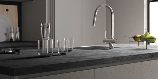 Moderne AKP-Küchenarbeitsplatte mit einem eleganten Wasserhahn vor einem grauen Hintergrund, mit einem Wasserkrug und Gläsern auf der Arbeitsplatte und einer Schale mit grünen Früchten auf einem Tisch in der Nähe.