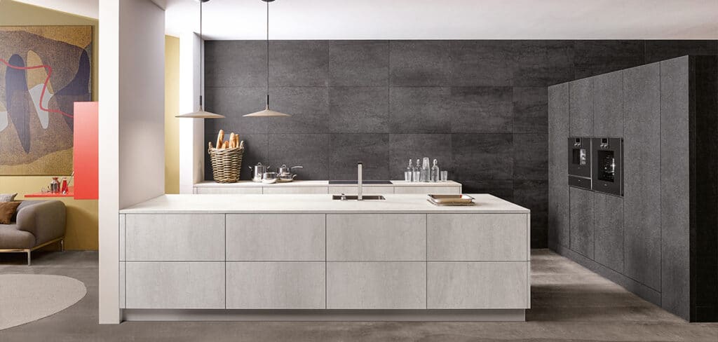 Eine moderne Küche mit einer großen Mittelinsel, eleganten Schränken und einer dunkel gefliesten Rückwand in einem klaren und minimalistischen Design.